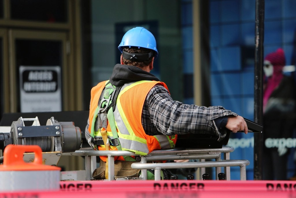 Profissional de colete orientando a equipe em obra
