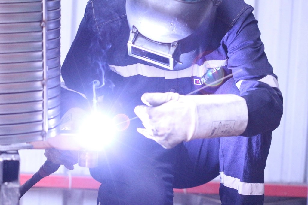 Soldador trabalhando com máscara de proteção